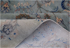 A vintage Persian Kashan rug with a sage green floral pattern and a visible cotton foundation.