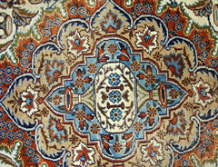 A vintage Persian Kashmar rug featuring an intricate floral medallion pattern in blue and rust tones.
