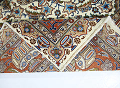 A vintage Persian Kashmar rug with intricate floral patterns in blue, red, and cream tones.