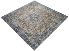 A vintage Persian Kerman rug featuring an intricate floral medallion in blue and beige tones.