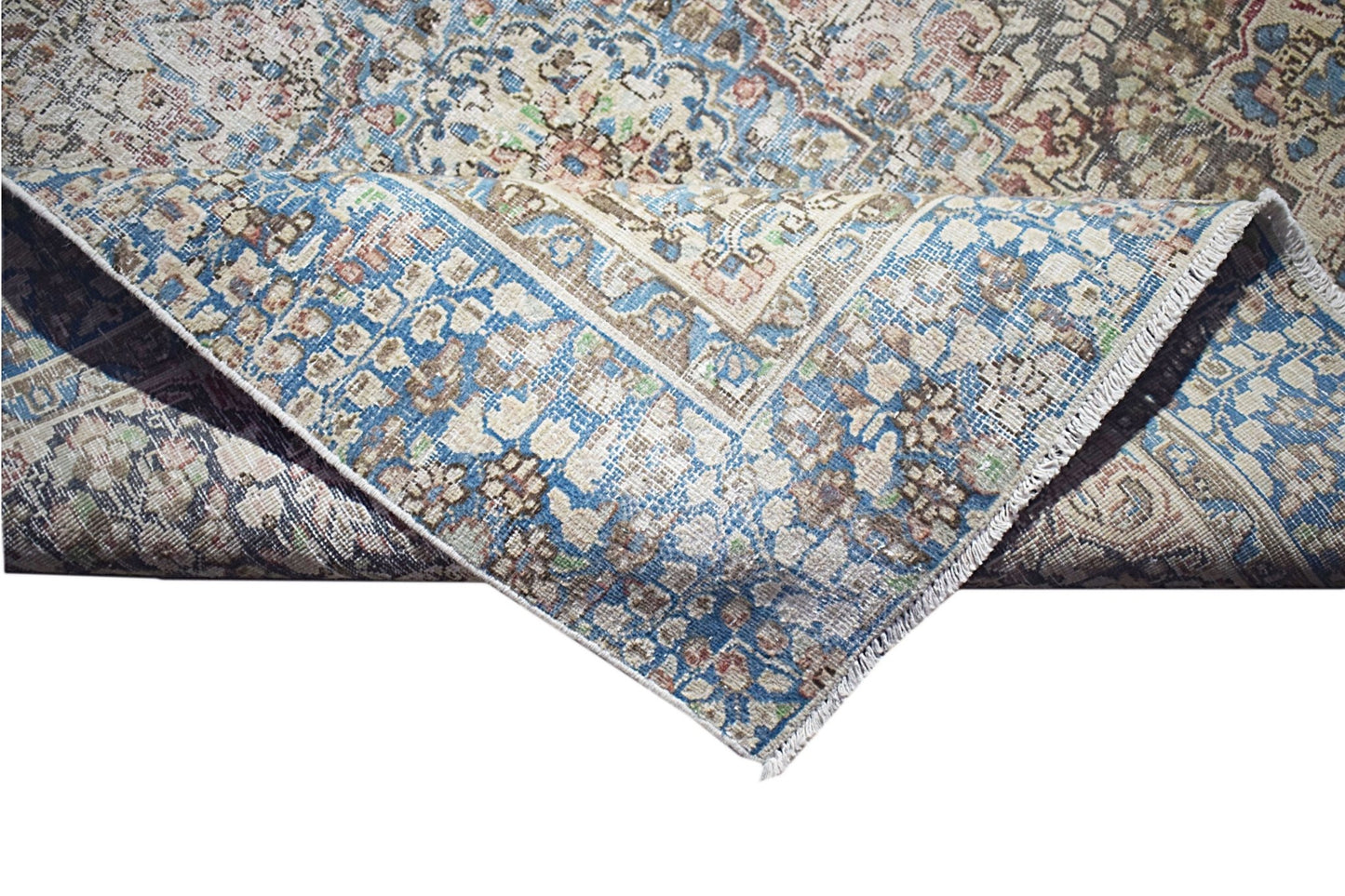 A vintage Persian Kerman rug featuring an intricate floral medallion pattern in blue and beige.