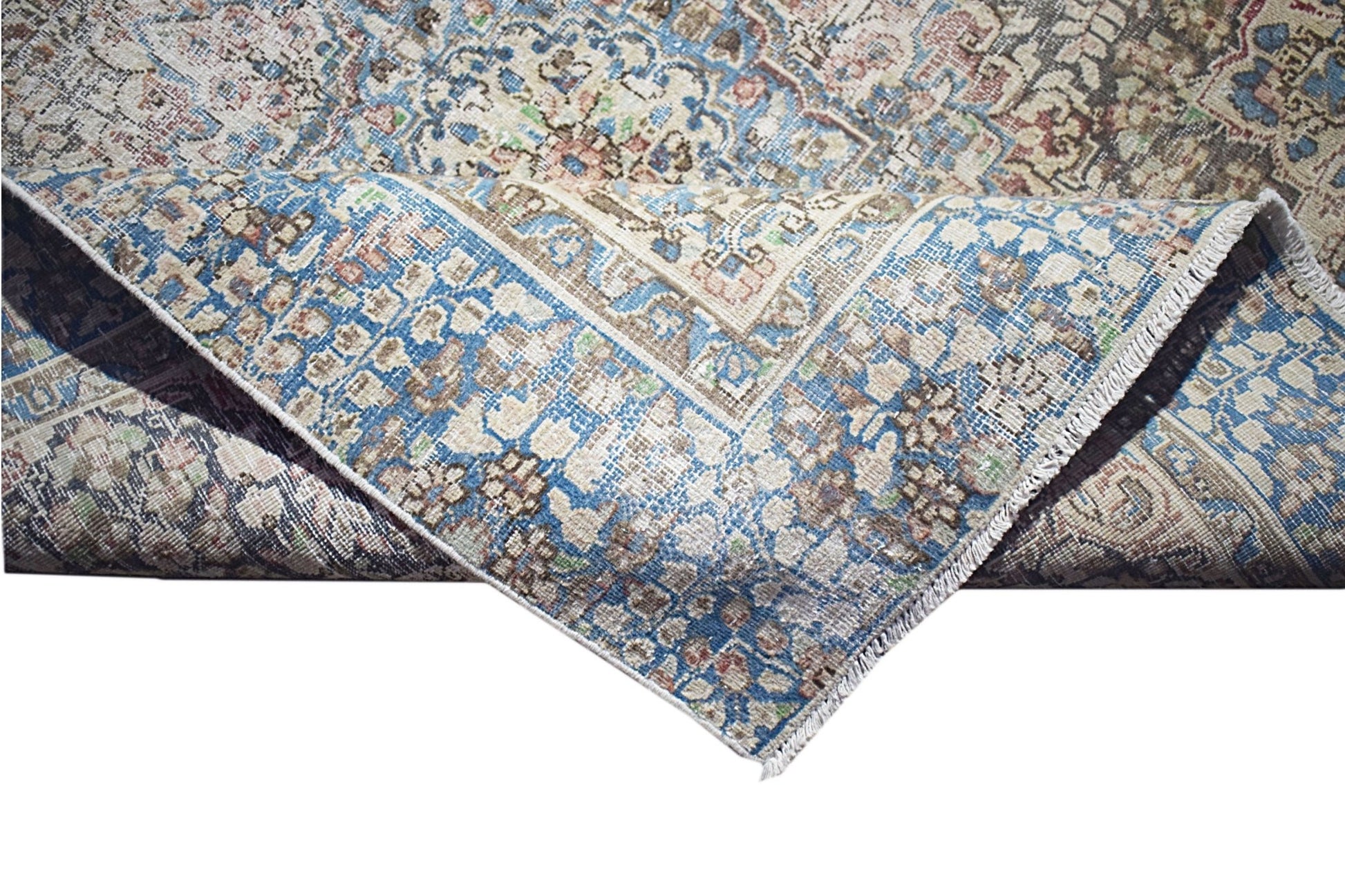 A vintage Persian Kerman rug featuring an intricate floral medallion pattern in blue and beige.