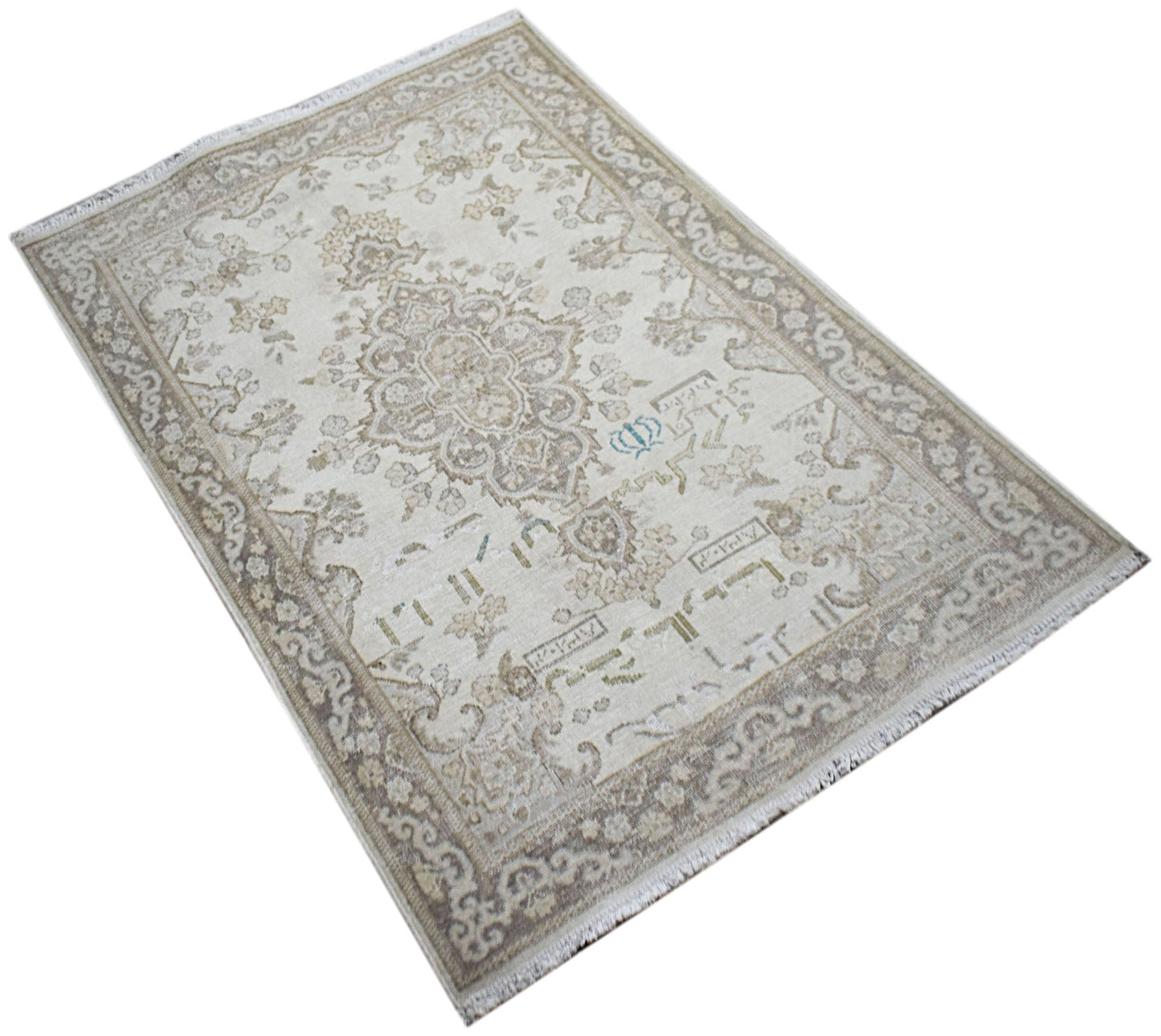 A vintage Persian Kerman rug featuring a central medallion and intricate floral patterns in beige.
