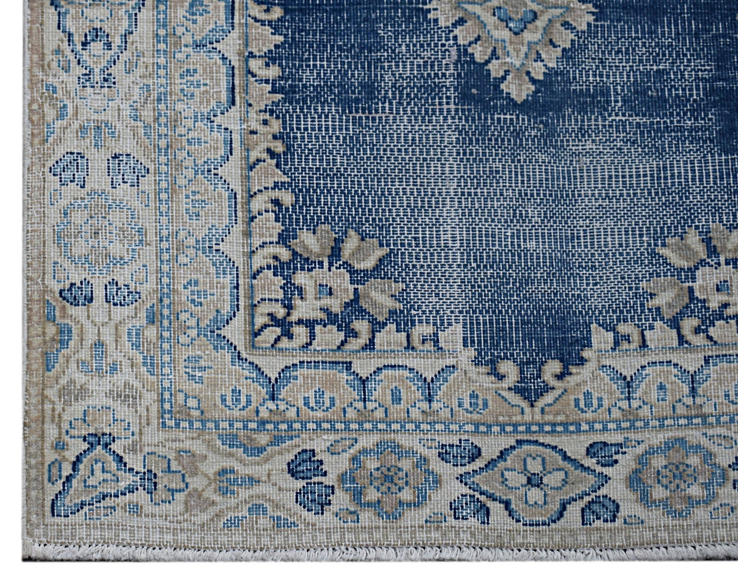 A vintage Persian Kerman rug featuring a blue field with intricate floral patterns and a border.