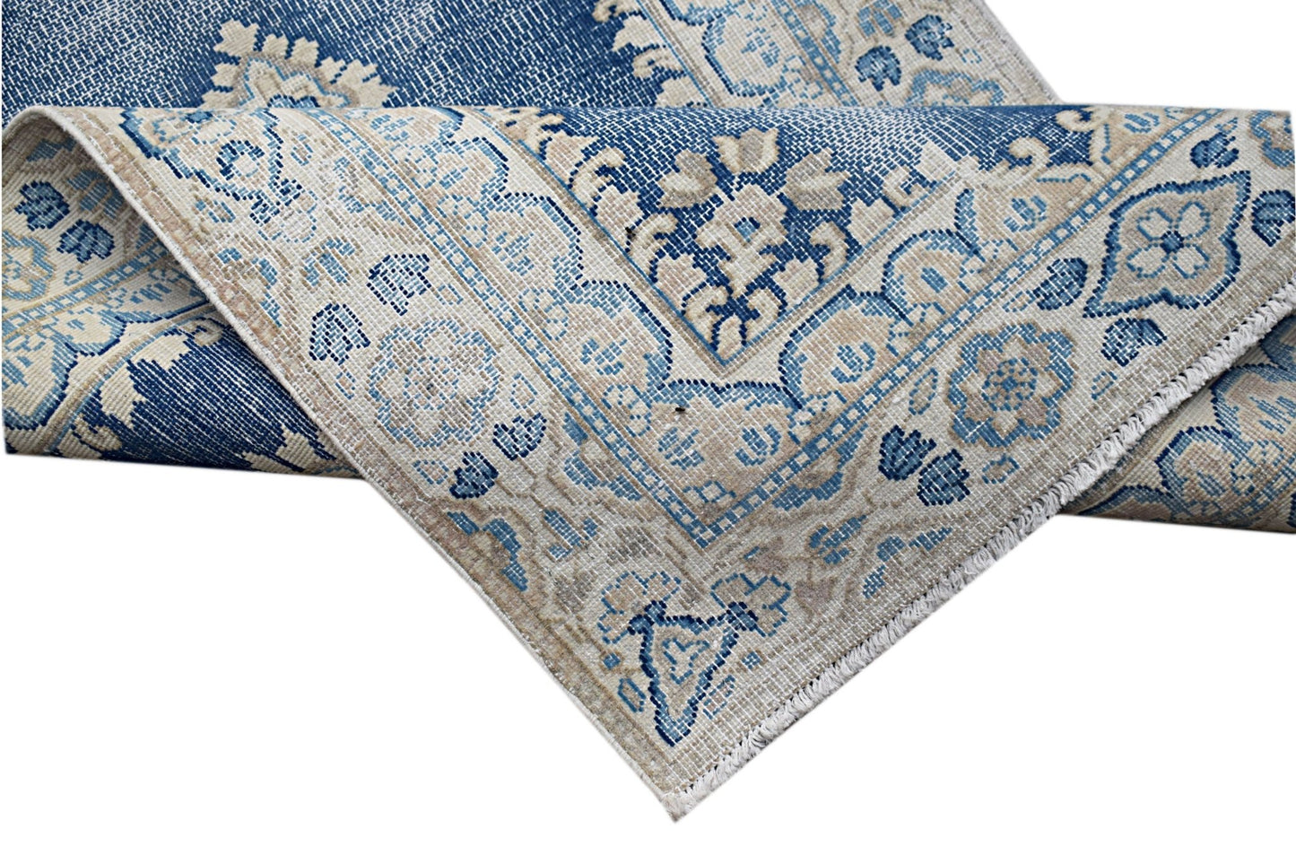 A vintage Persian Kerman rug featuring a blue and beige floral medallion pattern.