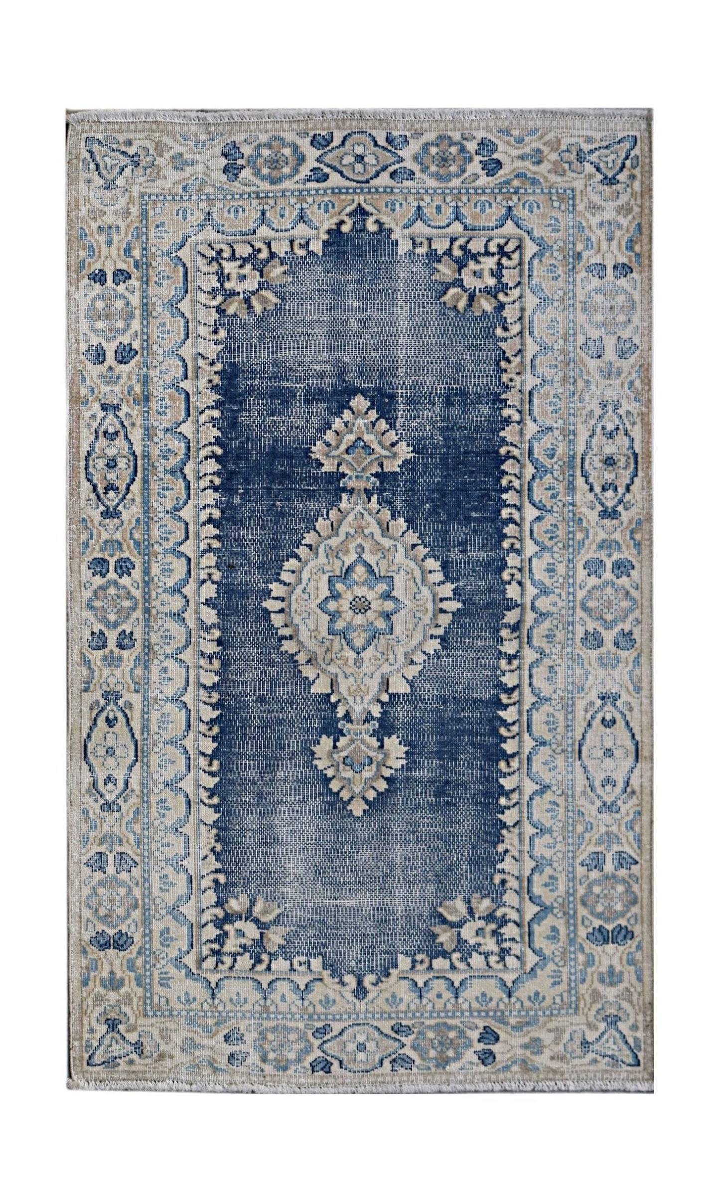 A vintage Persian Kerman rug featuring a central medallion on a blue field with floral borders.