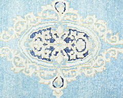 A vintage Persian Kerman rug featuring a central blue and cream floral medallion design.