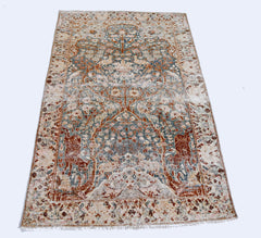 A vintage Persian Kerman rug featuring an intricate floral tree of life design in muted tones.