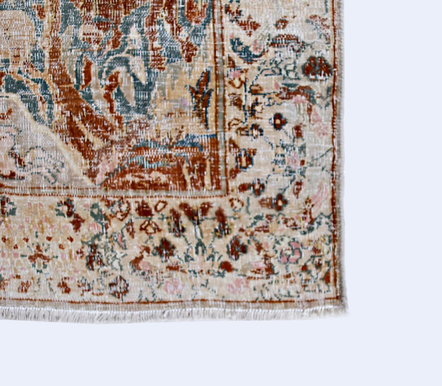 A vintage Persian Kerman rug featuring intricate floral patterns in muted earth tones.