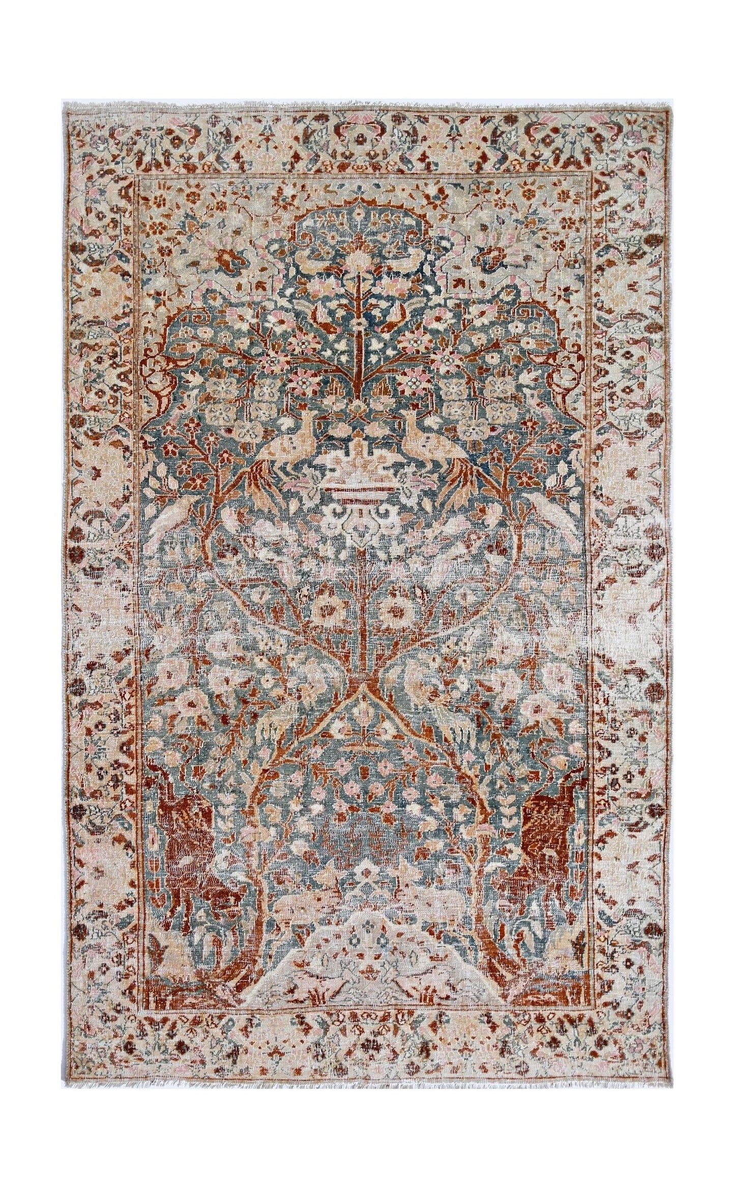 A vintage Persian Kerman rug featuring an intricate tree of life design in muted blue and rust tones.
