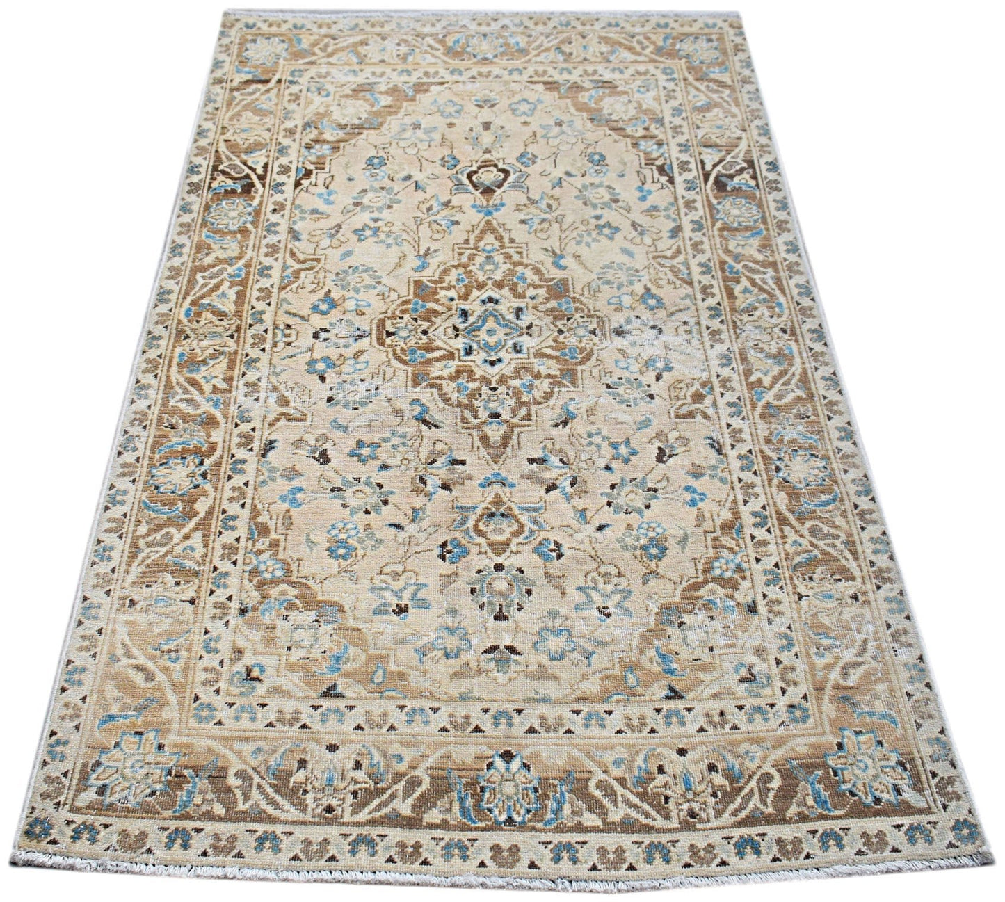 A vintage Persian Kerman rug featuring a central medallion and intricate floral patterns in blue and tan.