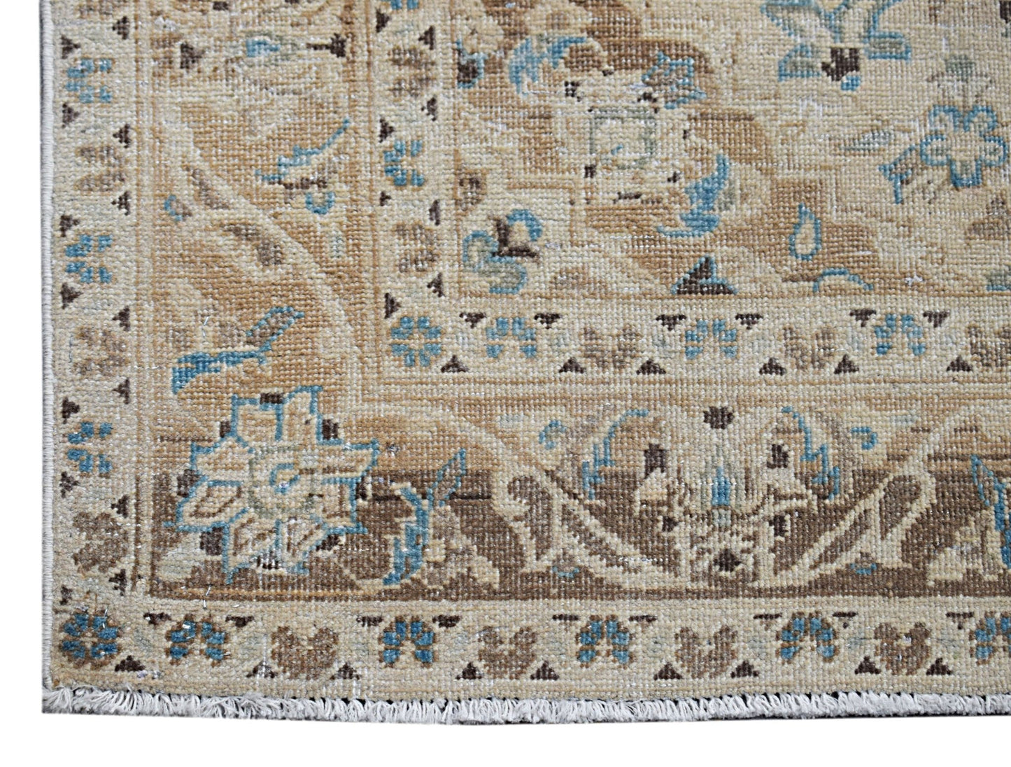 A vintage Persian Kerman rug featuring intricate floral patterns in shades of beige and blue.