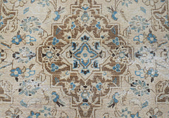 A vintage Persian Kerman rug featuring an intricate central medallion with blue and brown floral motifs.