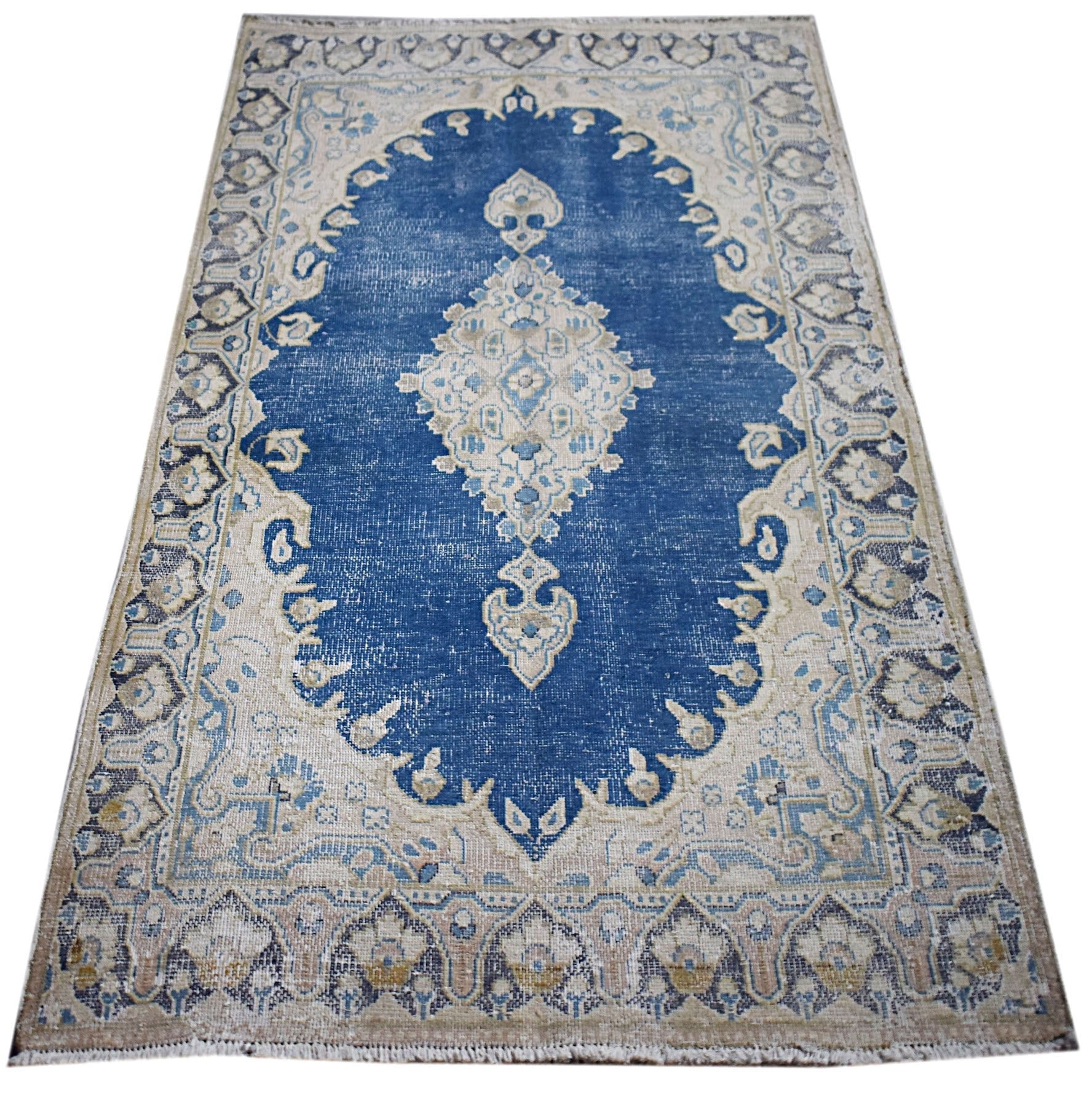 A vintage Persian Kerman rug featuring a central medallion on a blue field with floral borders.