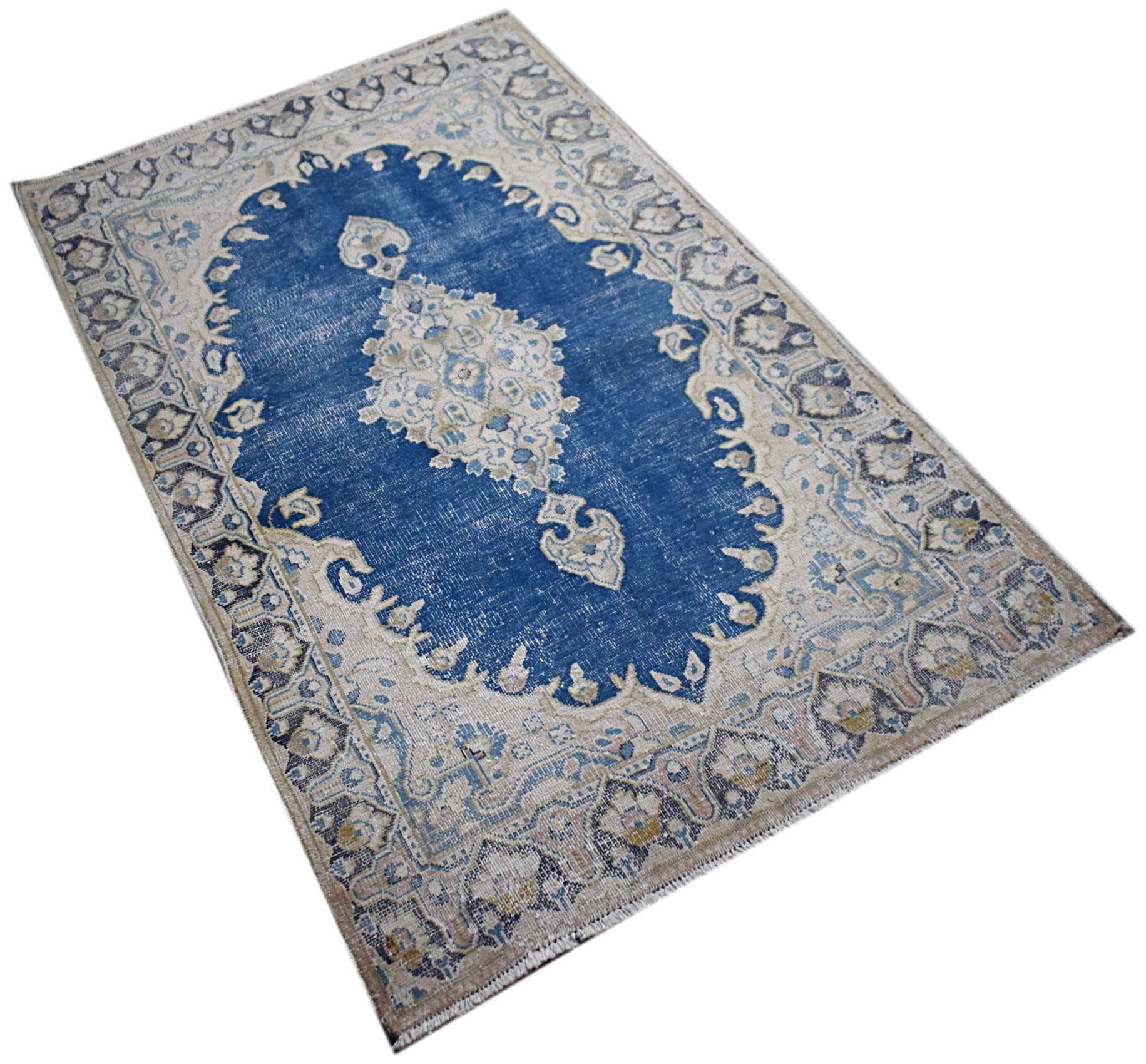 A vintage Persian Kerman rug featuring a central medallion on a blue field with floral borders.