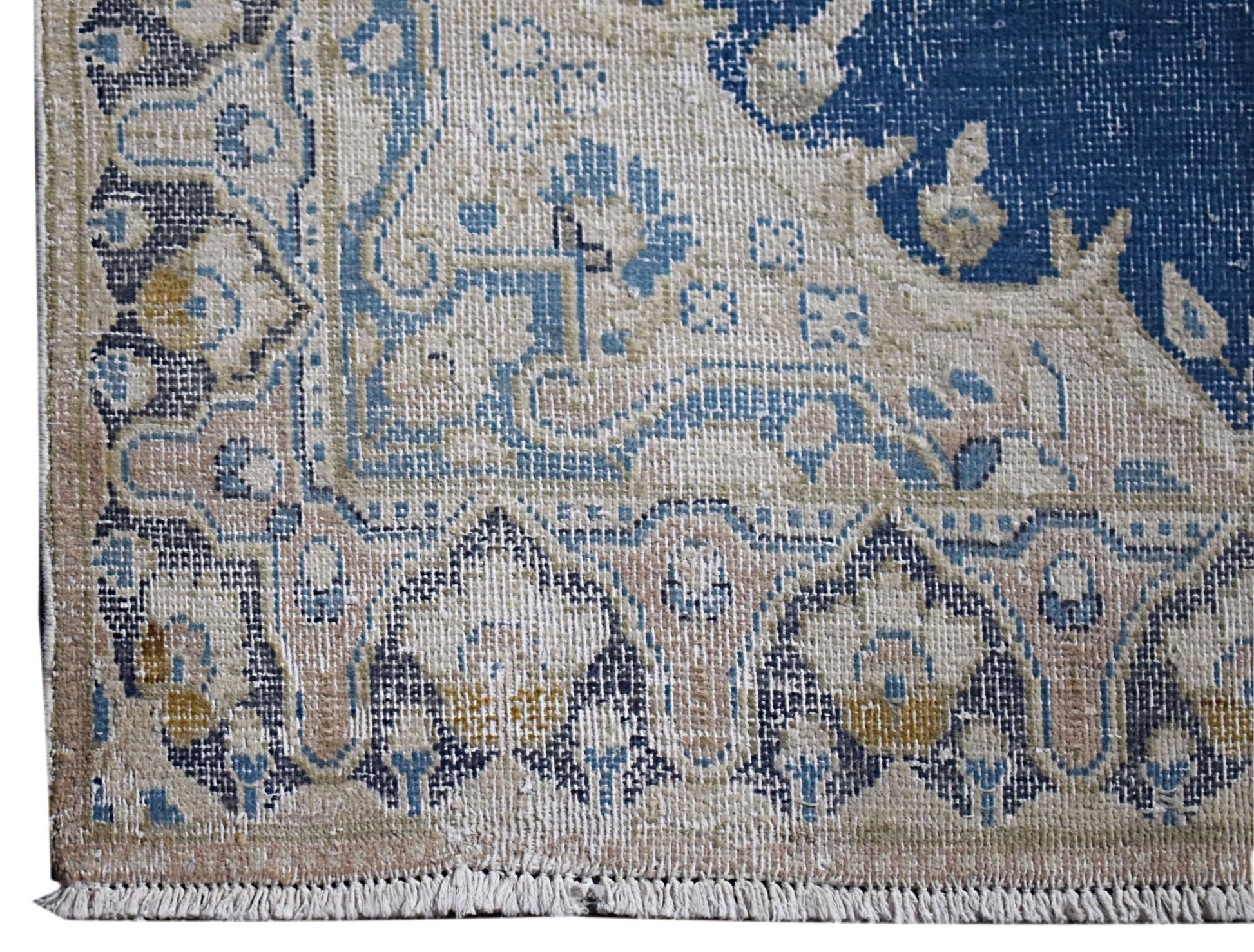 A vintage Persian Kerman rug featuring intricate floral patterns in blue, beige, and cream tones.