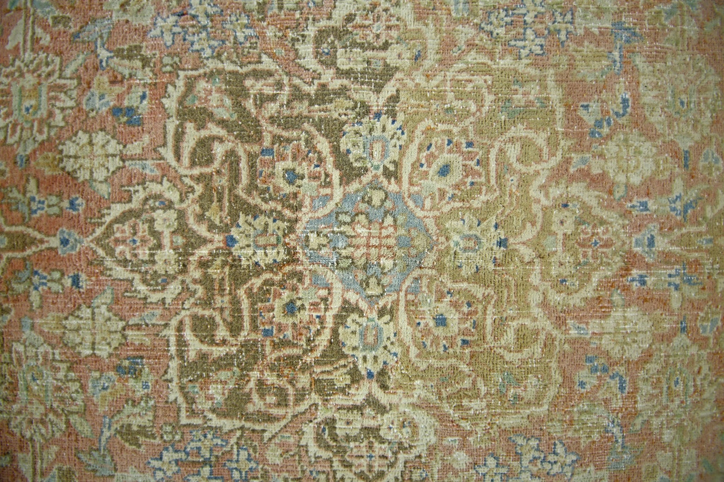 A vintage Persian rug featuring an intricate floral medallion pattern in muted earth tones.