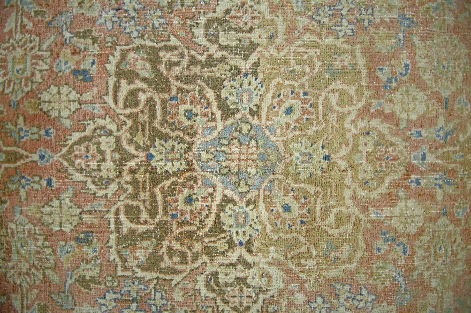 A vintage Persian rug featuring an intricate floral medallion pattern in muted earth tones.