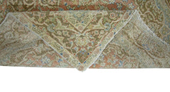 A vintage handmade Persian rug with a folded corner revealing its wool pile and cotton foundation.