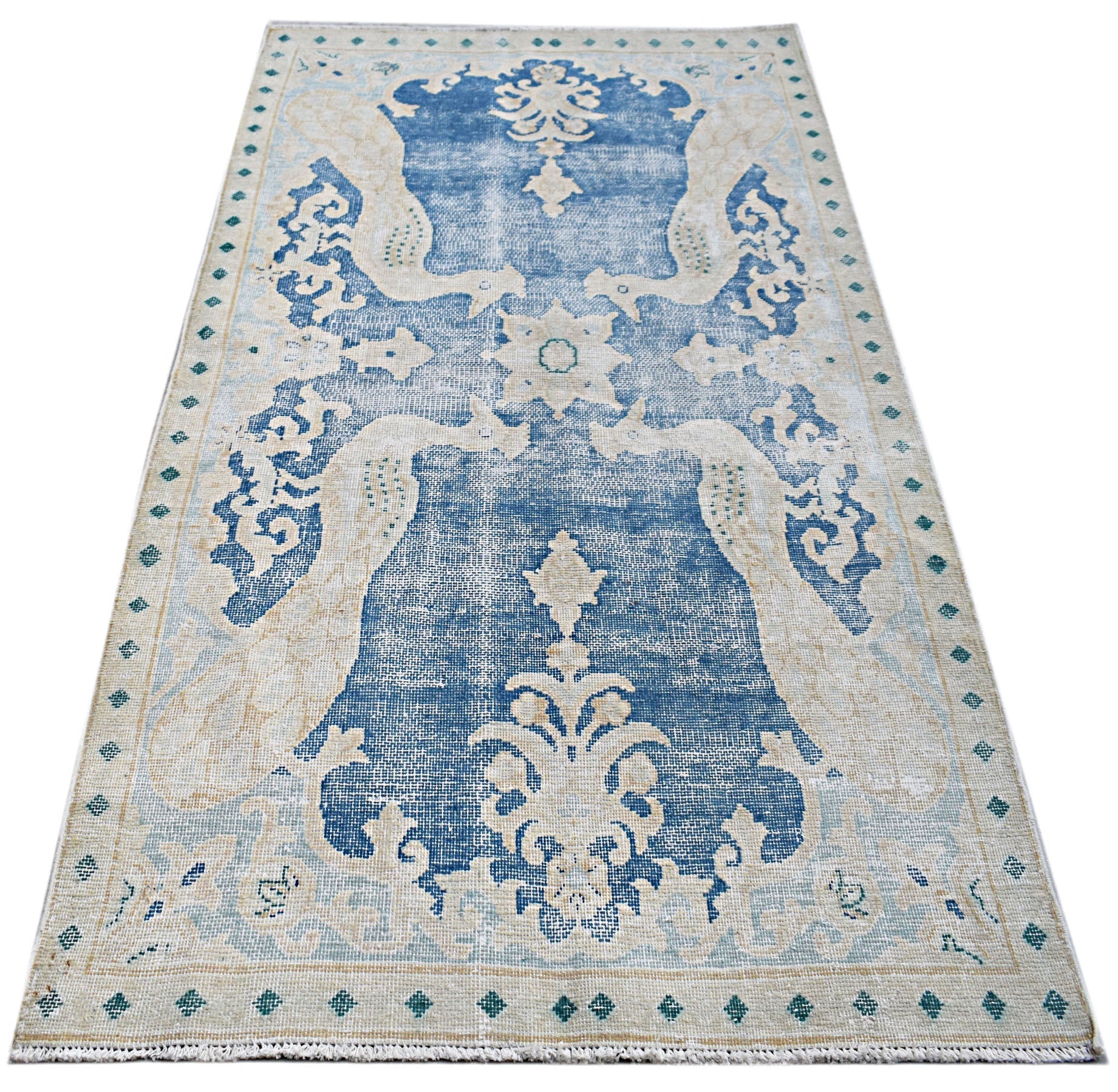 A vintage Persian Kerman rug featuring a blue central medallion and intricate floral motifs.
