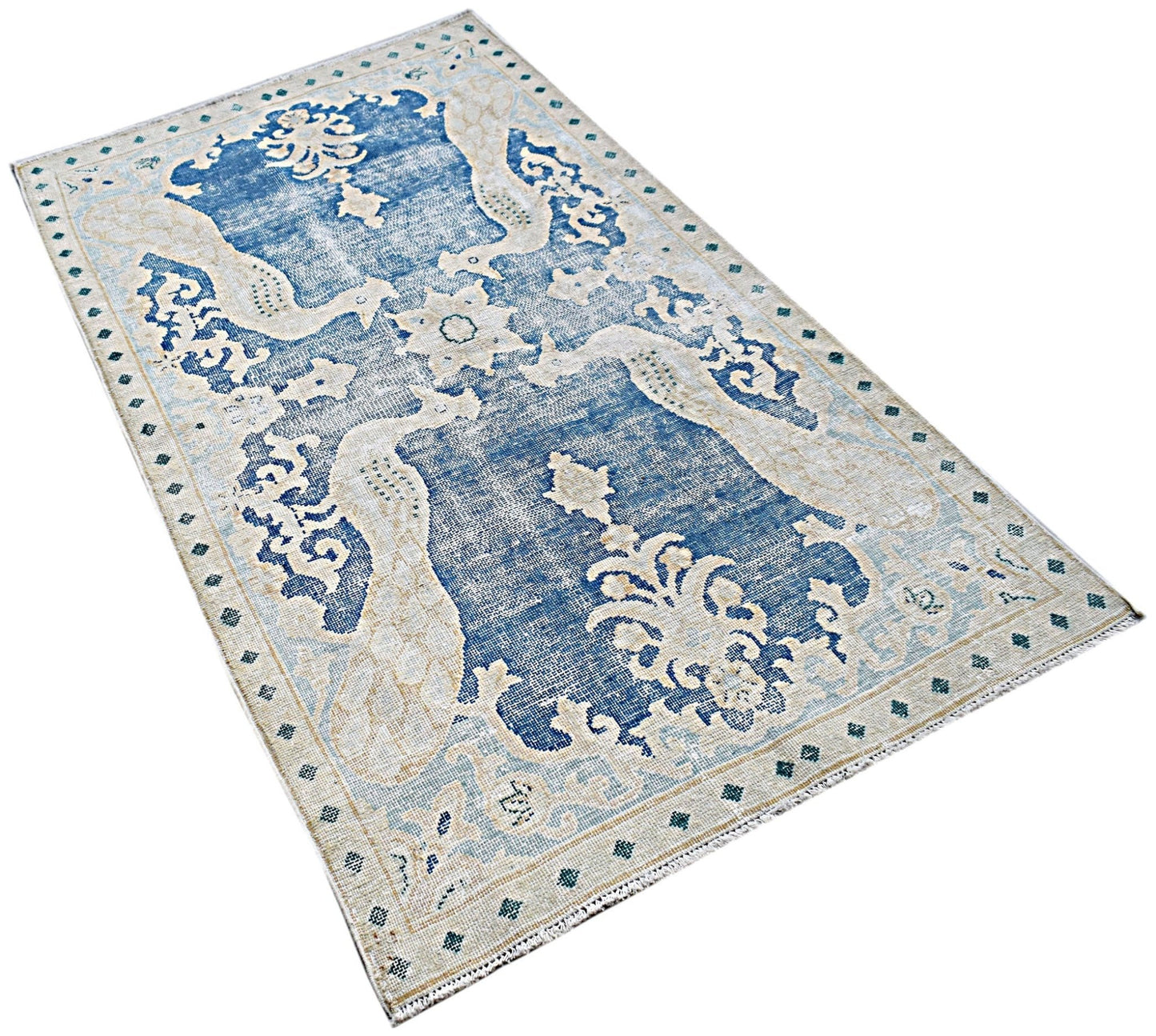 A vintage Persian Kerman rug featuring a blue field with intricate floral and bird motifs.
