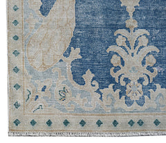 A vintage Persian Kerman rug featuring a blue field with intricate cream floral patterns.