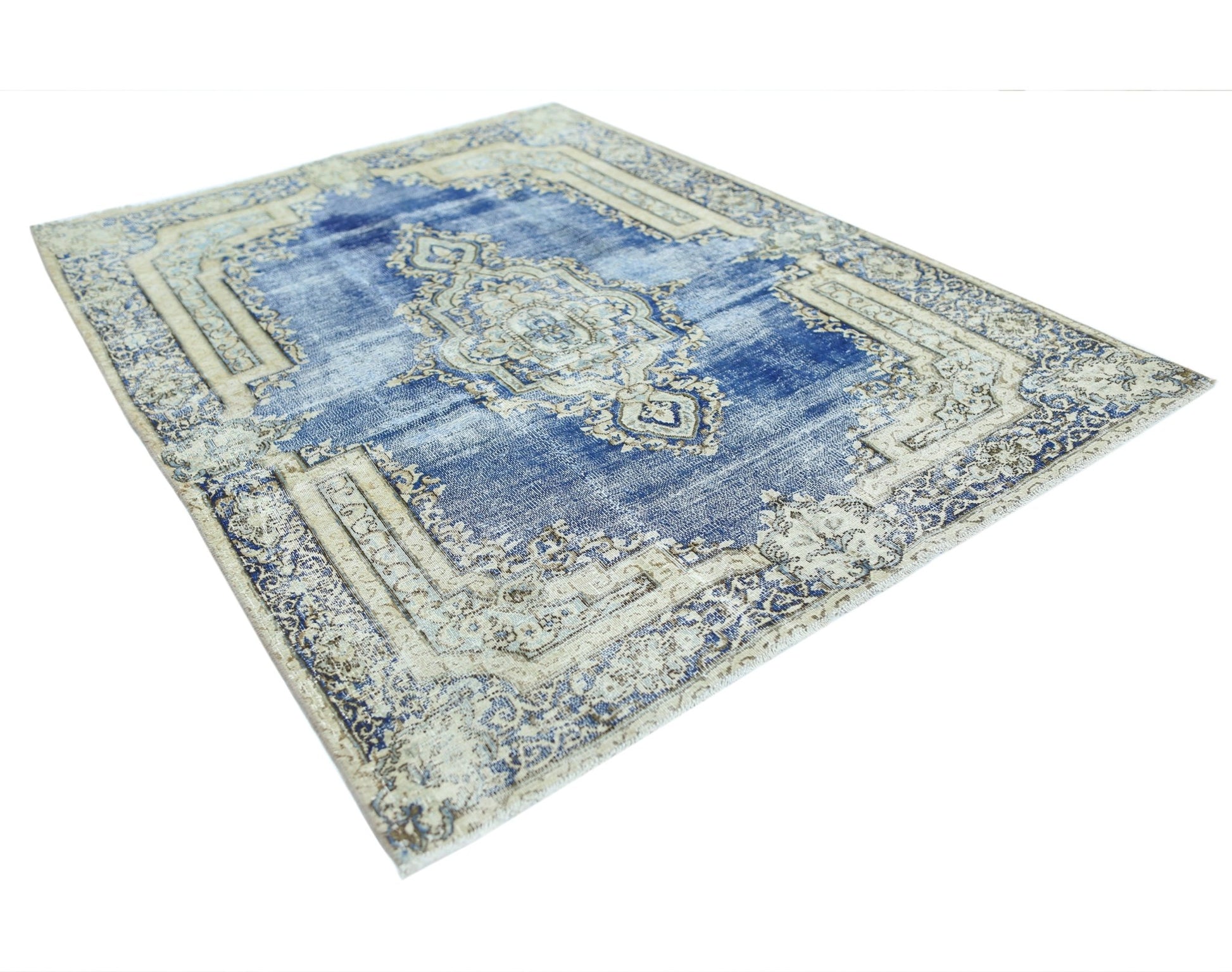 A vintage Persian Kerman rug featuring a central medallion and floral patterns in blue and cream.