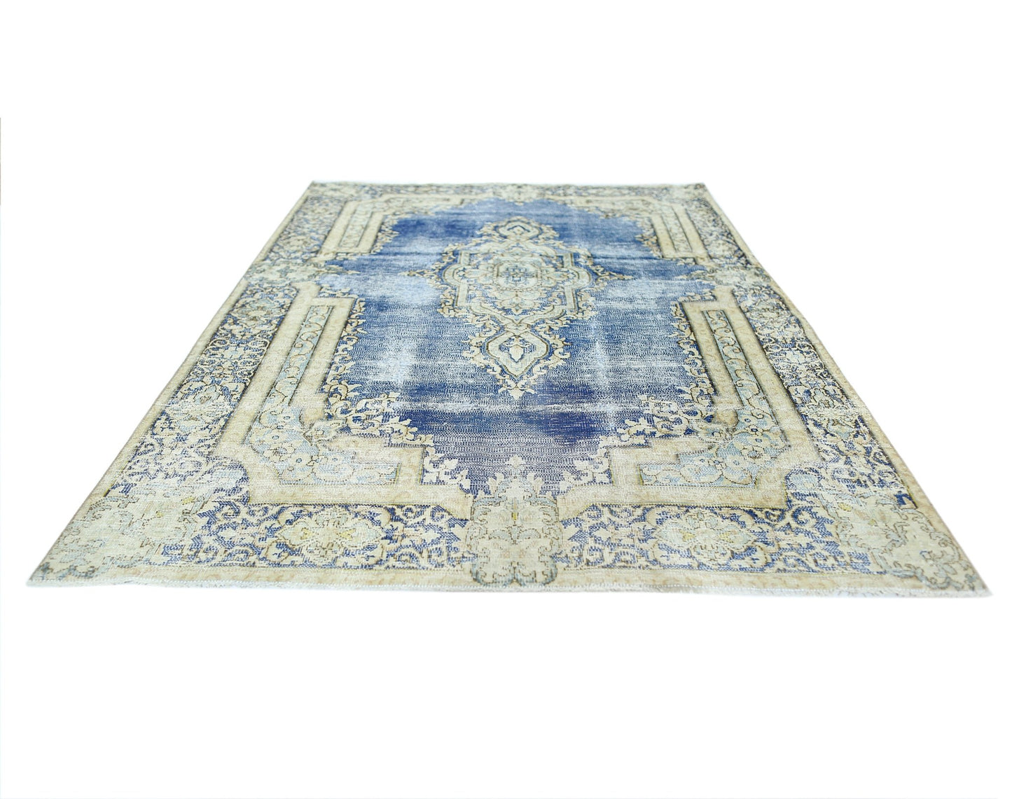 A vintage Persian Kerman rug featuring a central medallion and intricate floral patterns in blue.