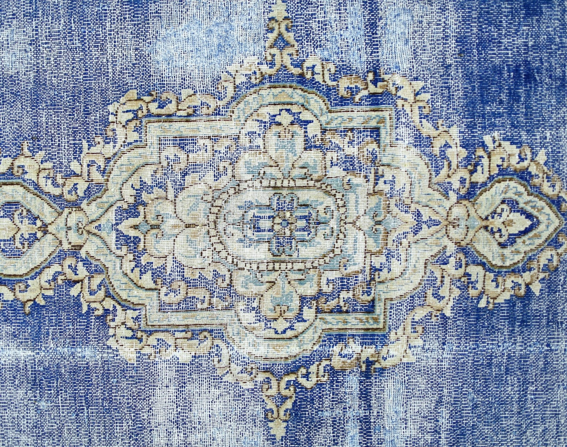 A vintage Persian Kerman rug featuring an intricate central medallion in shades of blue and cream.