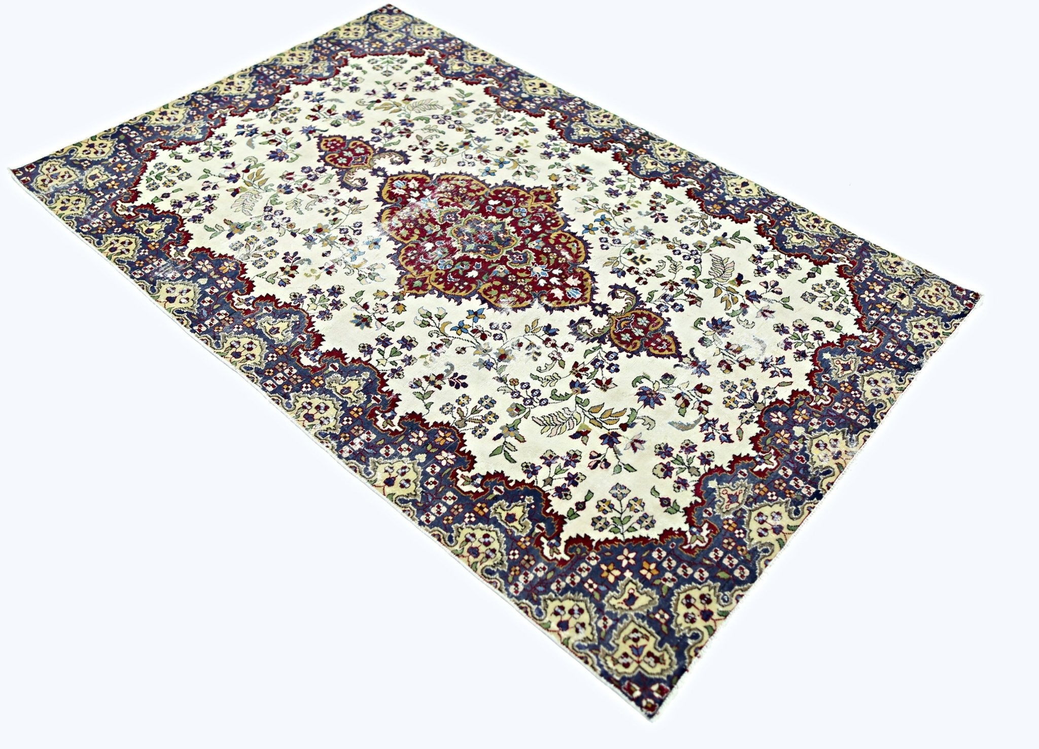 A vintage Persian Kerman rug featuring a central medallion and intricate floral patterns.