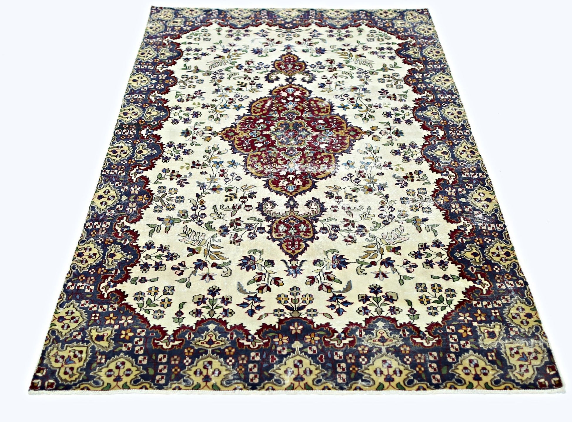 A vintage Persian Kerman rug featuring a central medallion and intricate floral patterns.
