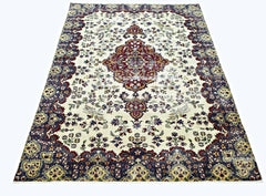 A vintage Persian Kerman rug featuring a central medallion and intricate floral patterns.