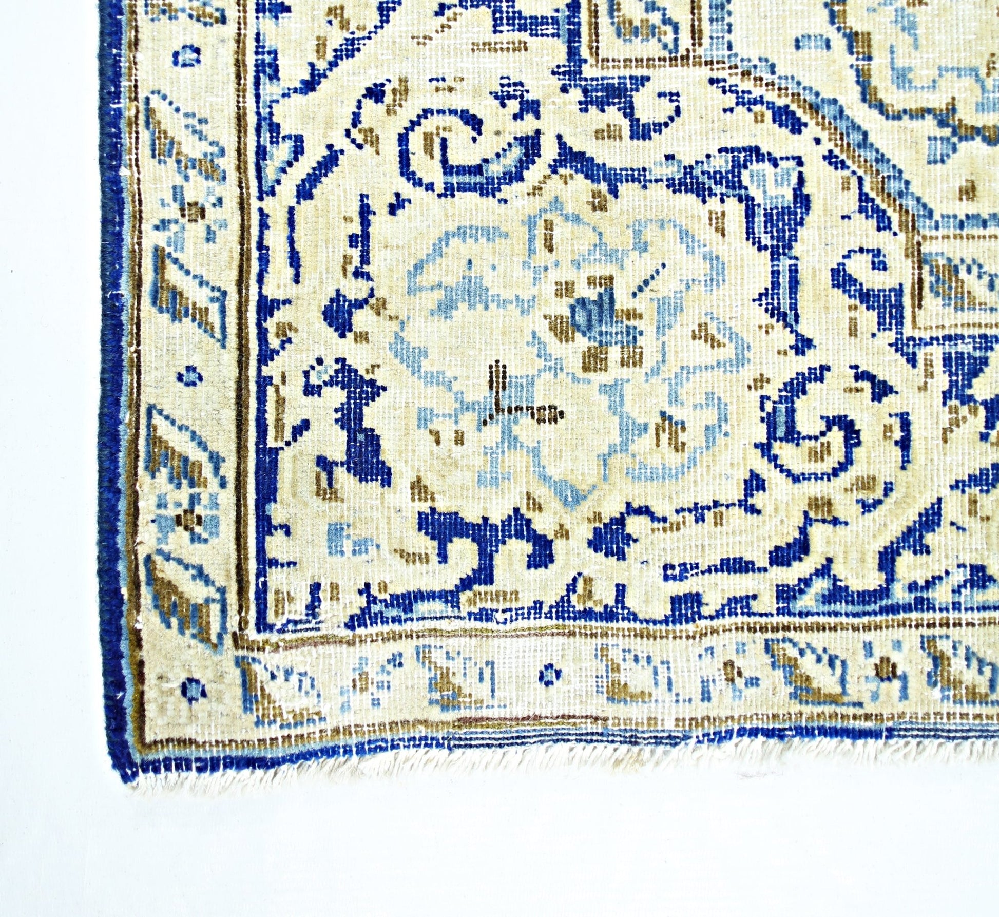 A vintage Persian Kerman rug featuring a blue and beige floral medallion pattern.
