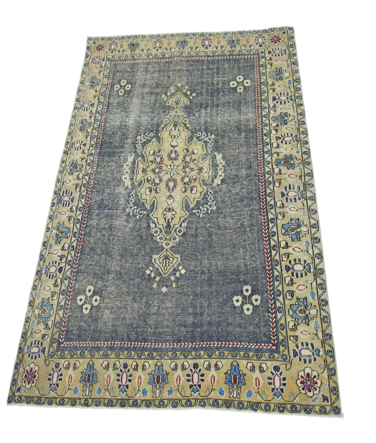 A vintage Persian Kerman rug featuring a central medallion on a distressed blue field.