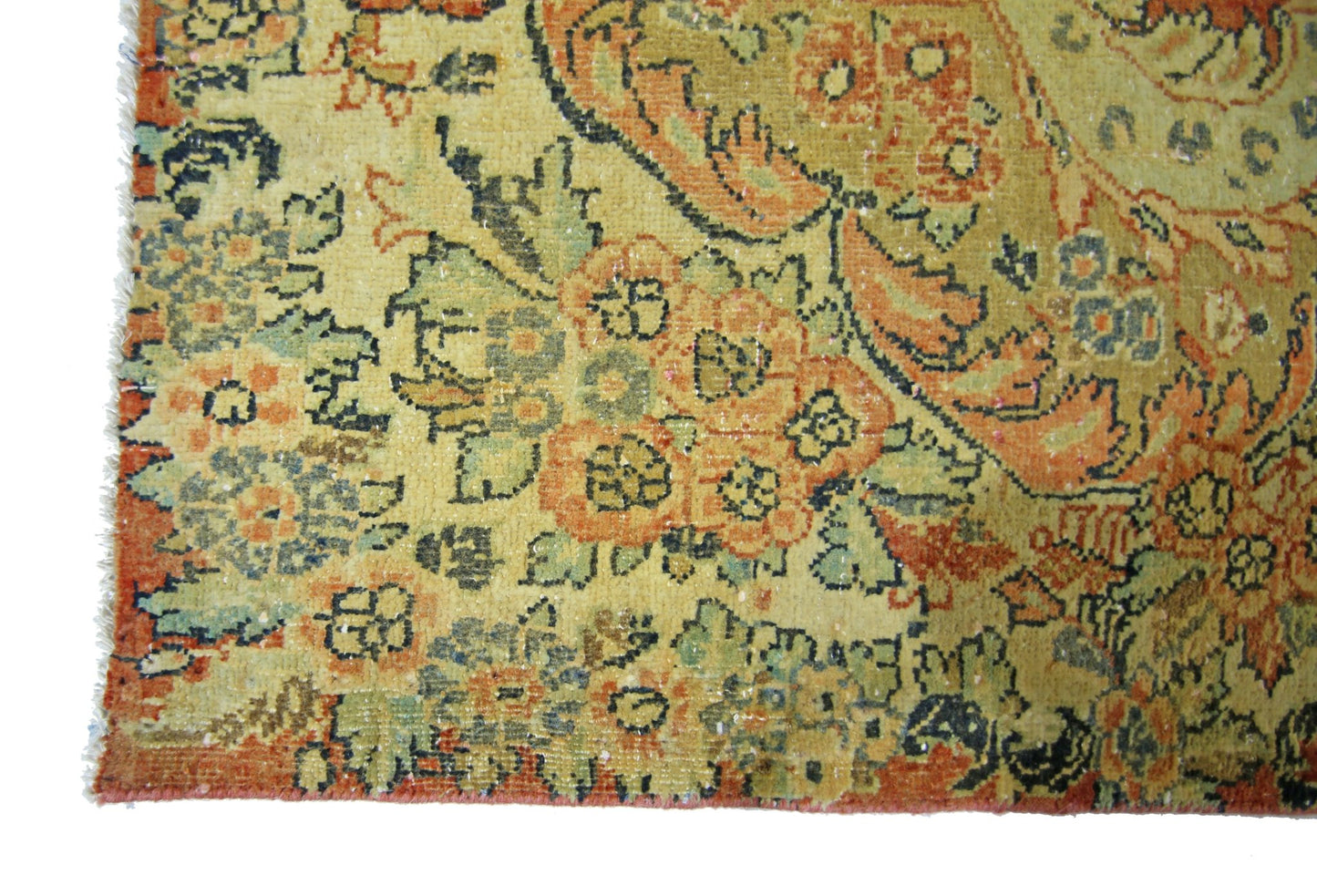 A vintage Persian Kerman rug featuring intricate floral patterns in muted orange and green tones.