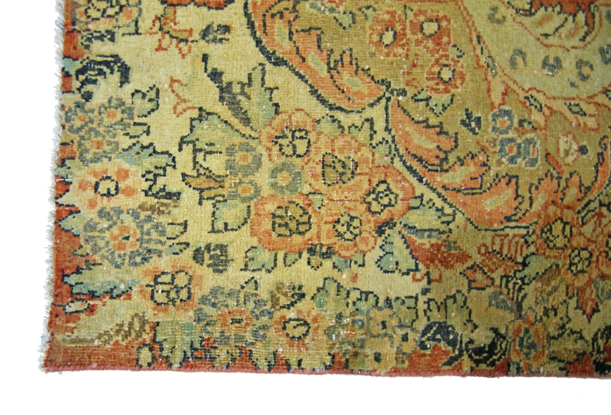A vintage Persian Kerman rug featuring intricate floral patterns in muted orange and green tones.