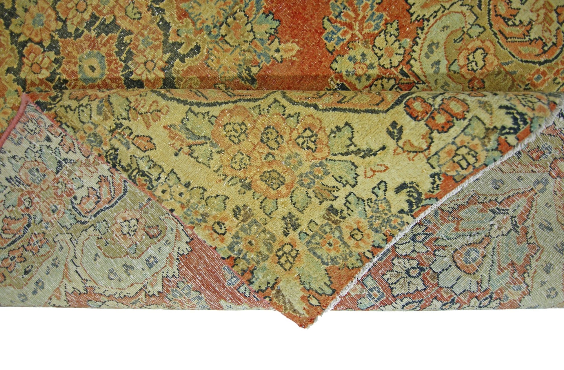 A vintage Persian Kerman rug featuring an intricate floral pattern in muted orange and green tones.