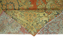 A vintage Persian Kerman rug featuring an intricate floral pattern in muted orange and green tones.