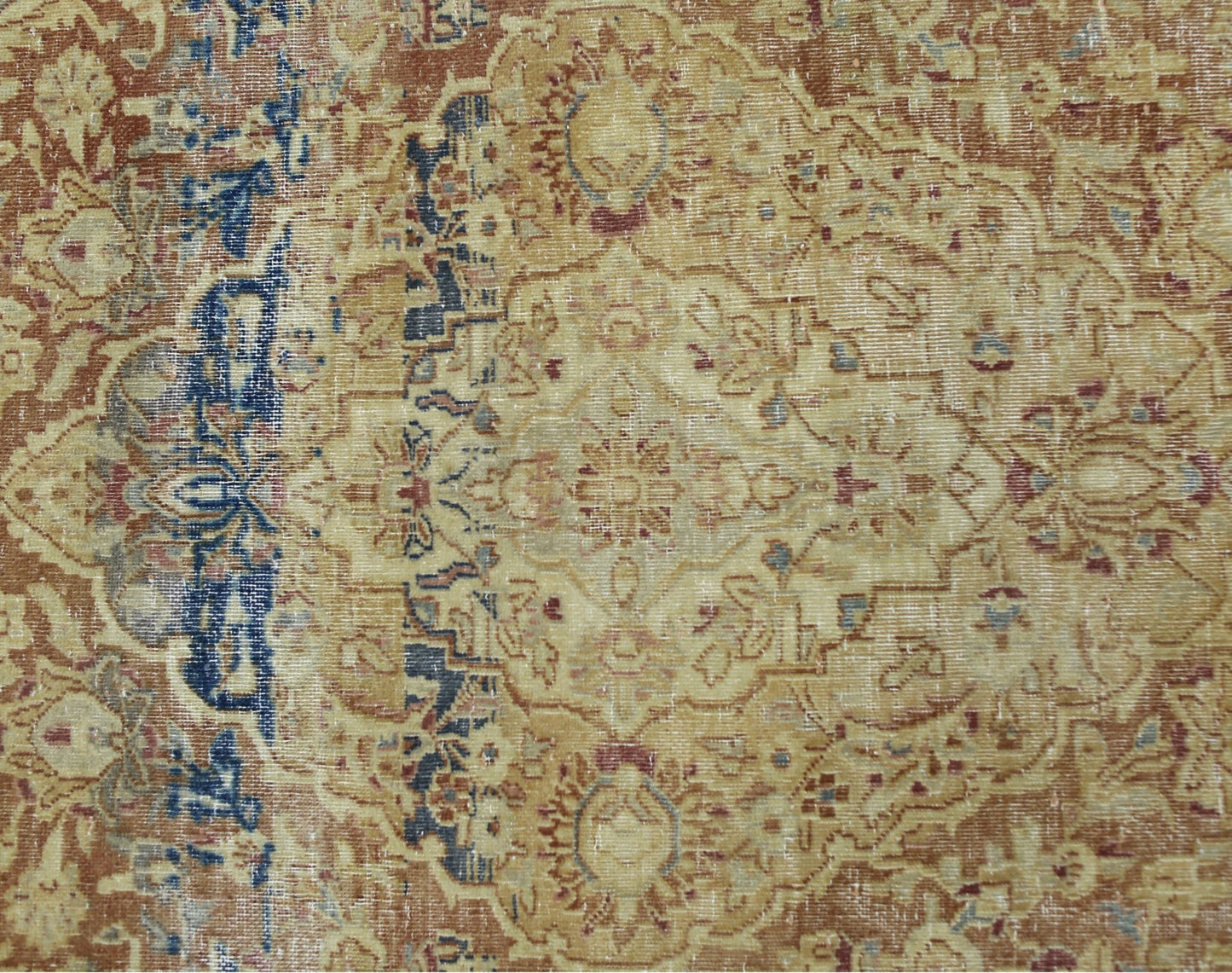 A vintage Persian Kerman rug featuring an intricate floral medallion in muted earth tones.