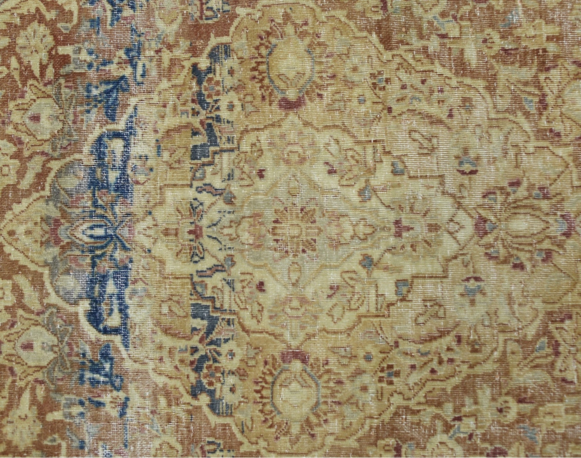 A vintage Persian Kerman rug featuring an intricate floral medallion in muted earth tones.
