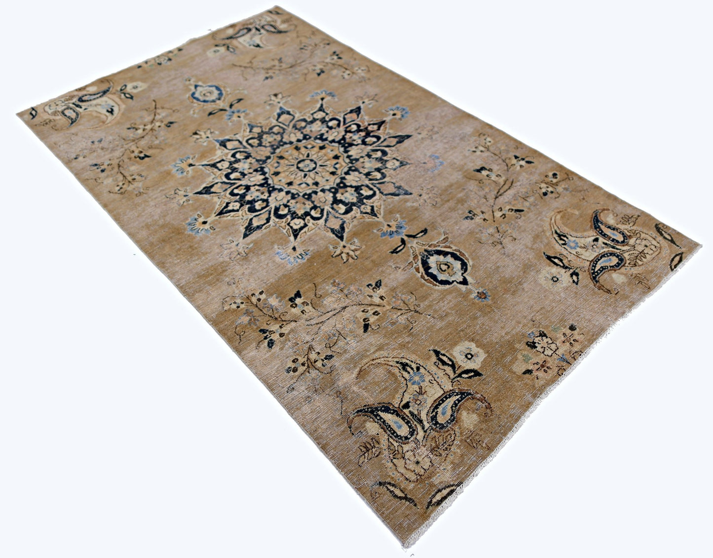 A vintage Persian Kerman rug featuring a central medallion and floral motifs on a tan field.