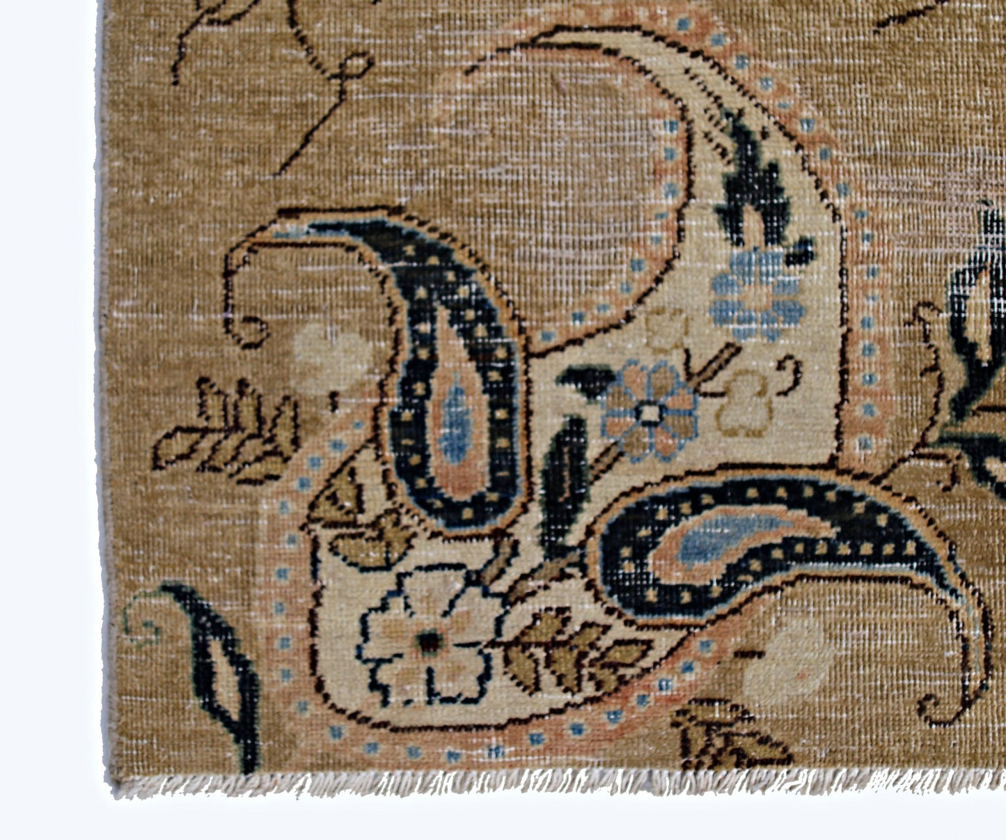 A close-up of a vintage Persian Kerman rug featuring intricate floral and paisley motifs.