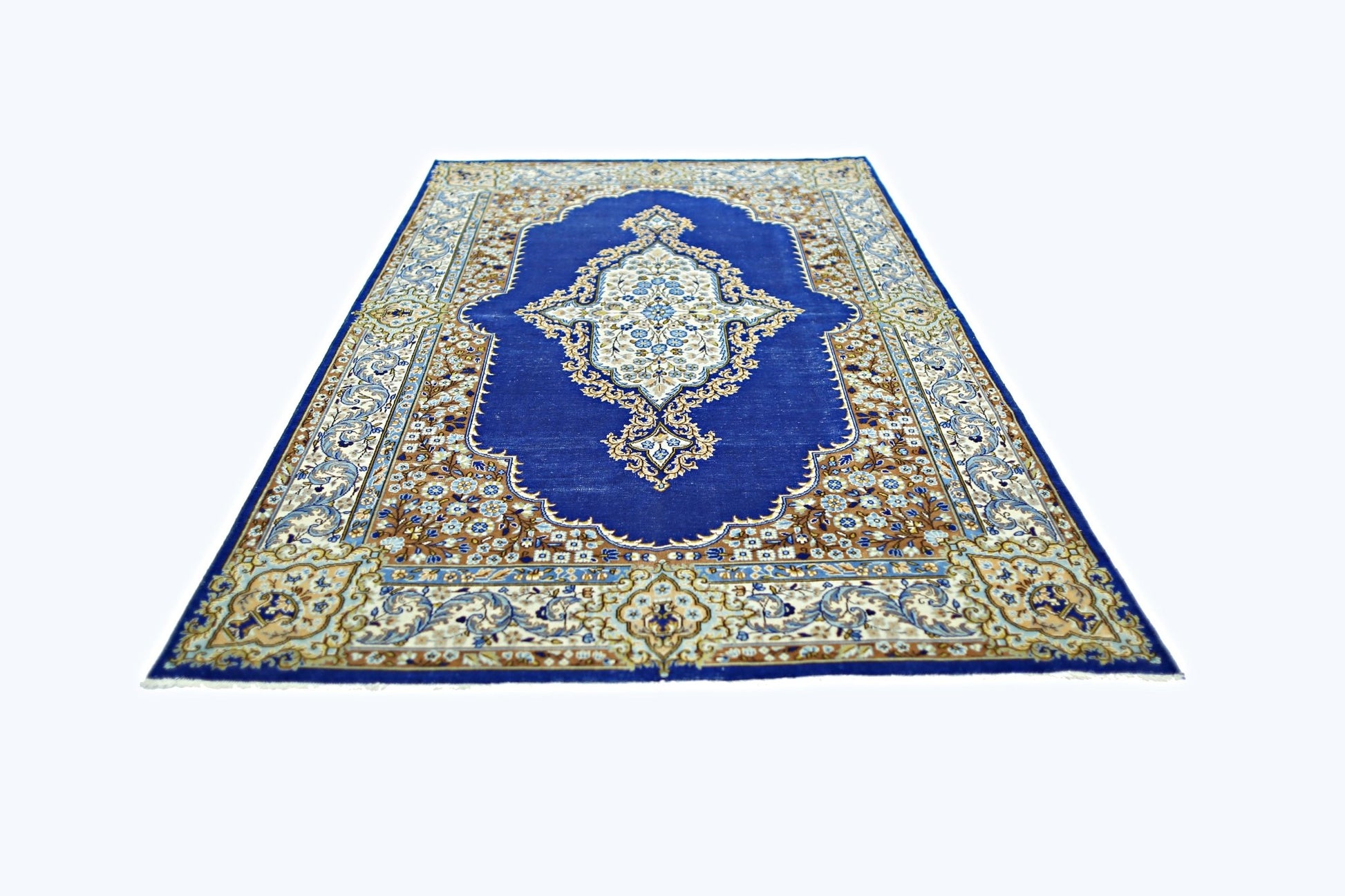 A vintage Persian Kerman rug featuring a central floral medallion on a deep blue field.