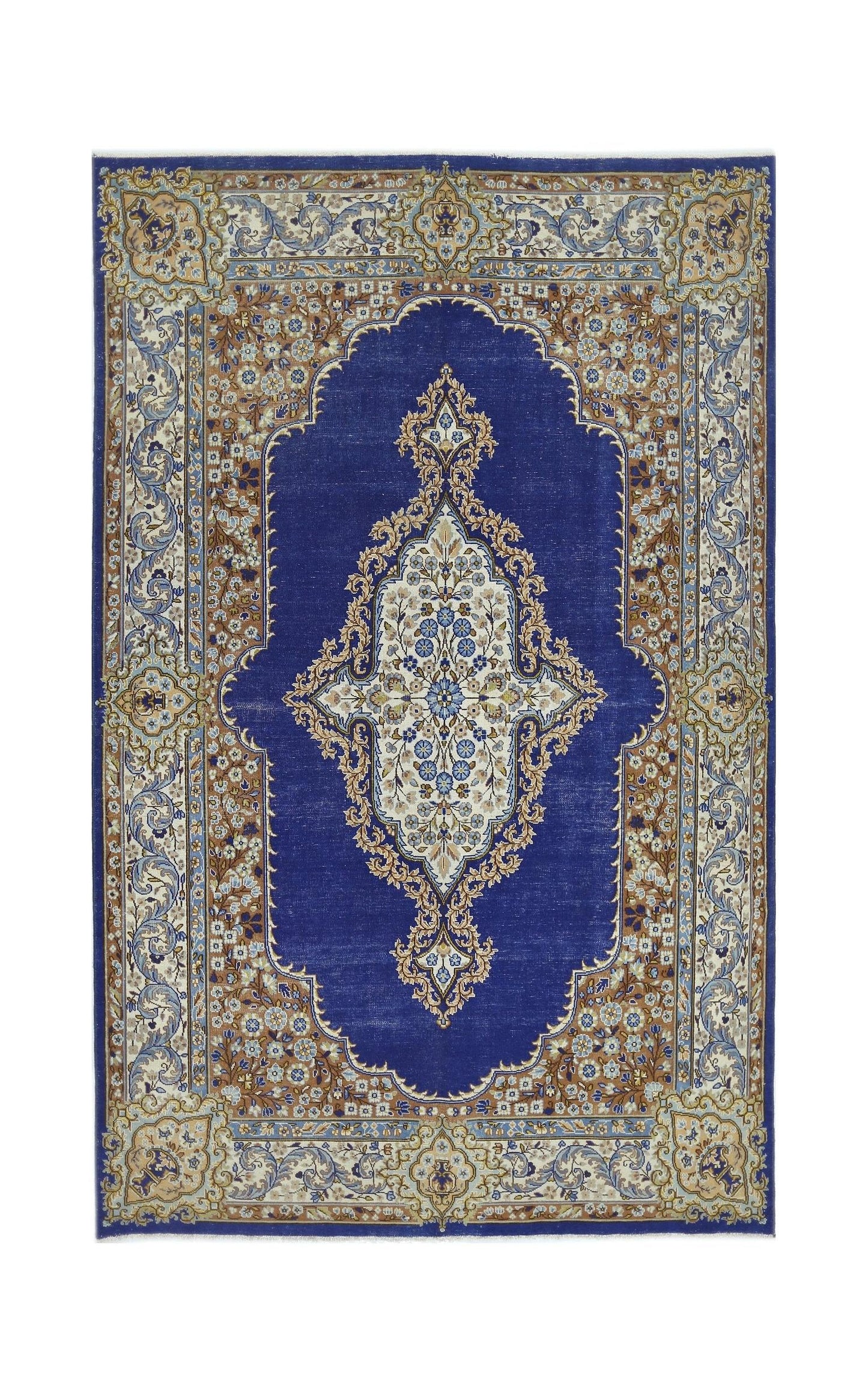 A vintage Persian Kerman rug featuring a central floral medallion on a deep blue field.