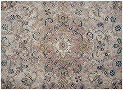 A vintage Persian Kerman rug featuring a central floral medallion in muted pink and blue tones.
