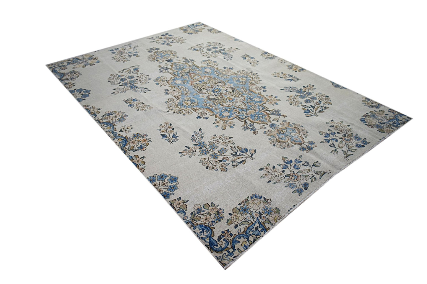 A vintage Persian Kerman rug featuring a central medallion and intricate floral patterns.