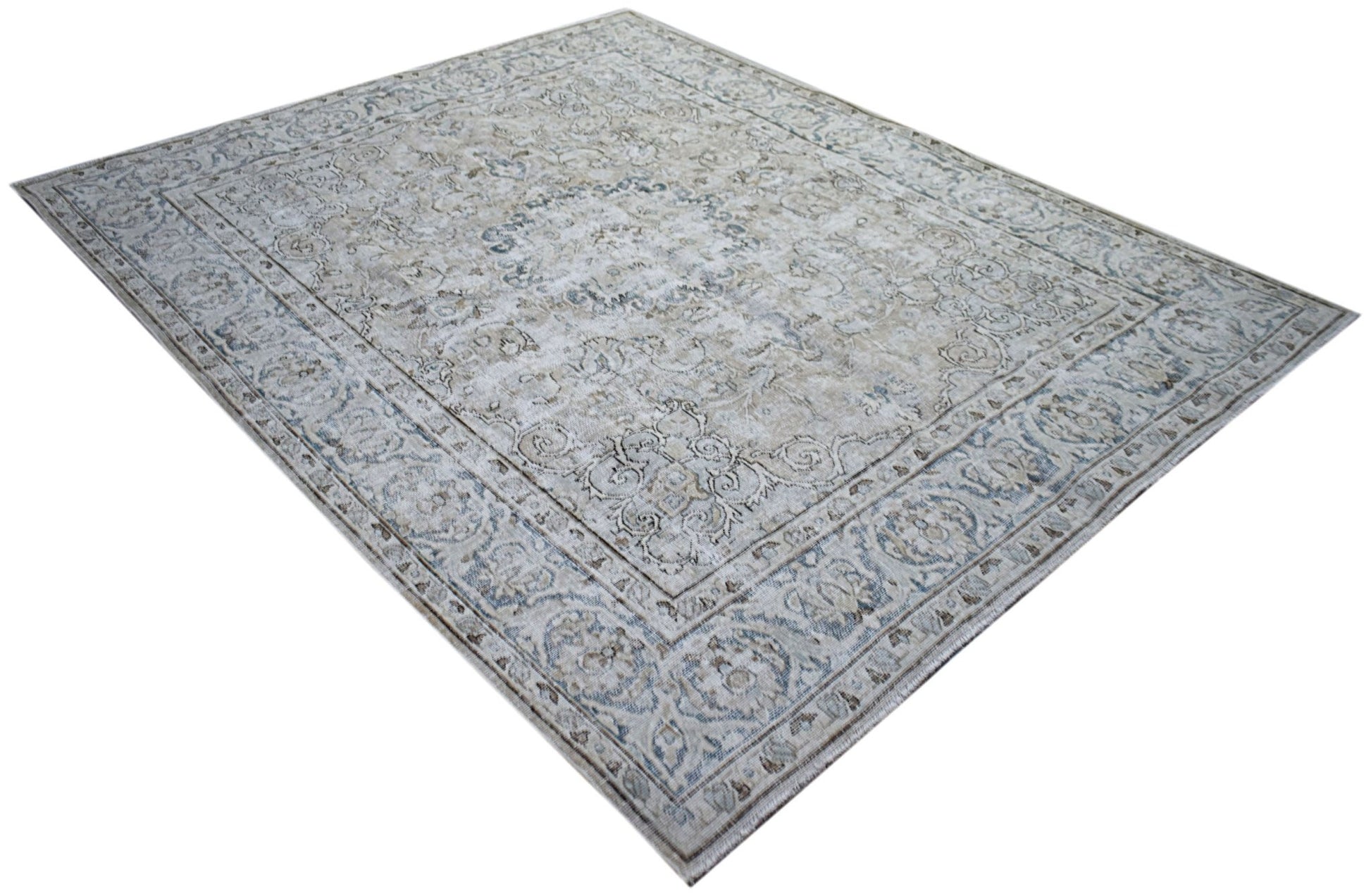 A vintage Persian Kerman rug featuring a central medallion and intricate floral patterns in blue.
