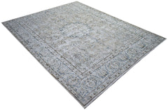 A vintage Persian Kerman rug featuring a central medallion and intricate floral patterns in blue.