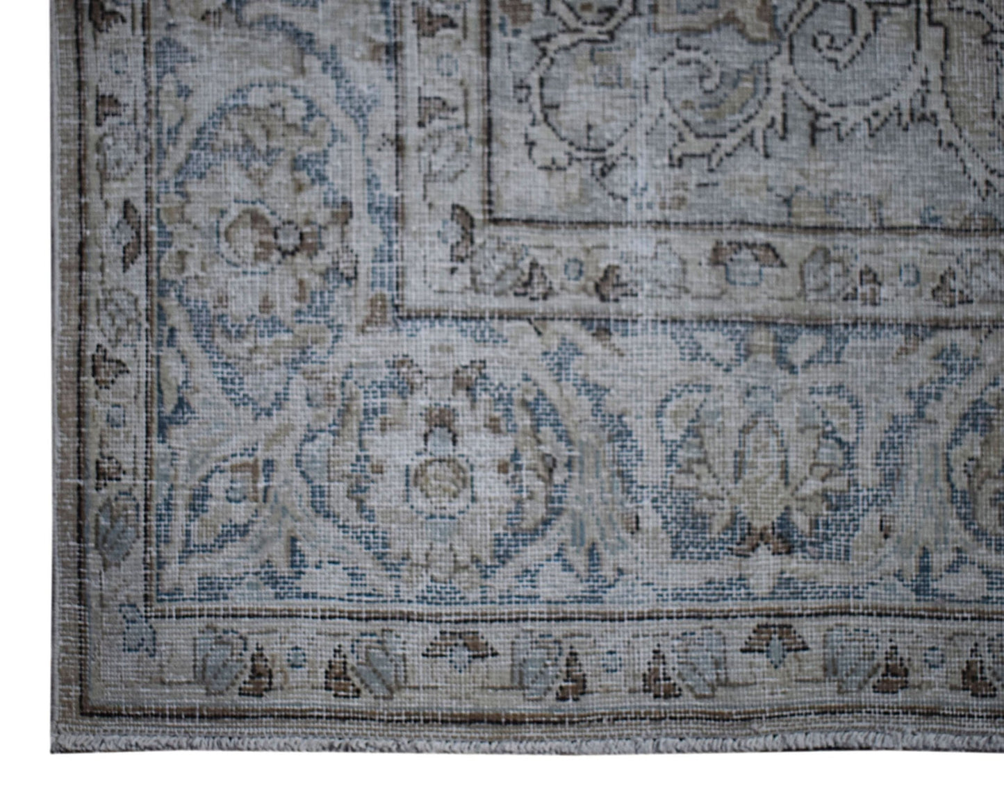 A vintage Persian Kerman rug featuring a faded floral medallion pattern in blue and beige tones.