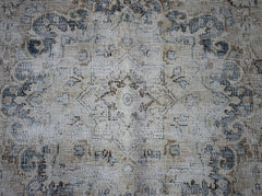 A vintage Persian Kerman rug featuring a central medallion with intricate floral patterns.
